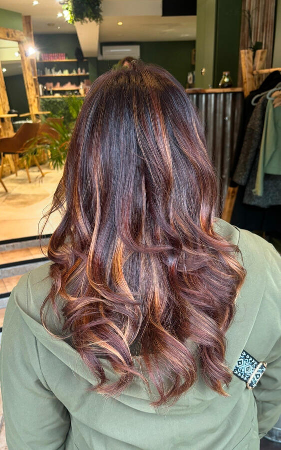 Une coloration cuivrée profonde aux reflets chauds, sublimée par de larges boucles souples sur cheveux longs. Le mélange de nuances rousses et miel apporte du relief et une brillance intense. ✨ Réalisée avec soin dans notre salon de coiffure à Saumur –