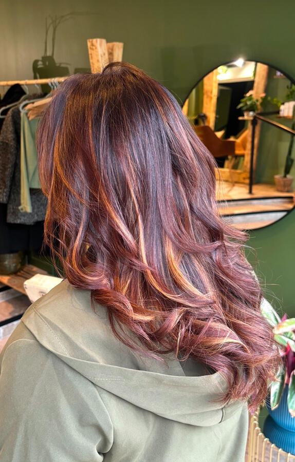 Une coloration cuivrée profonde aux reflets chauds, sublimée par de larges boucles souples sur cheveux longs. Le mélange de nuances rousses et miel apporte du relief et une brillance intense. ✨ Réalisée avec soin dans notre salon de coiffure à Saumur –