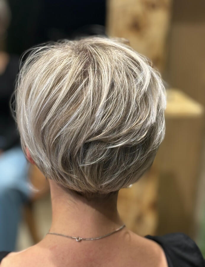 Une coupe courte féminine tout en légèreté, avec un joli dégradé travaillé pour créer du volume naturel à l’arrière. Le blond froid lumineux donne de l’éclat et souligne chaque mouvement. ✨ Réalisation signée La P’tite Brune, votre salon de coiffure à S