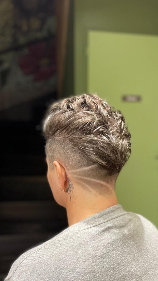 Un undercut précis avec dégradé net et motif graphique rasé à la tondeuse. Le dessus est coiffé en volume, pour un style dynamique et moderne. ✨ Réalisée au salon La P’tite Brune – spécialiste des coupes femme à Saumur.
